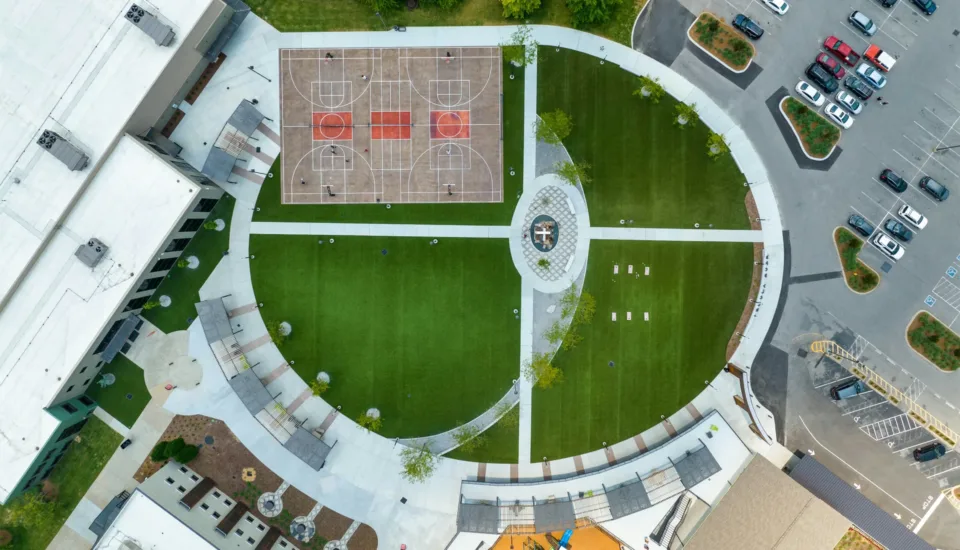 Long Hollow Baptist Church in Gallatin Tennessee aerial view featuring outdoor basketball courts, circular green space, and playground — church architecture by Visioneering Studios