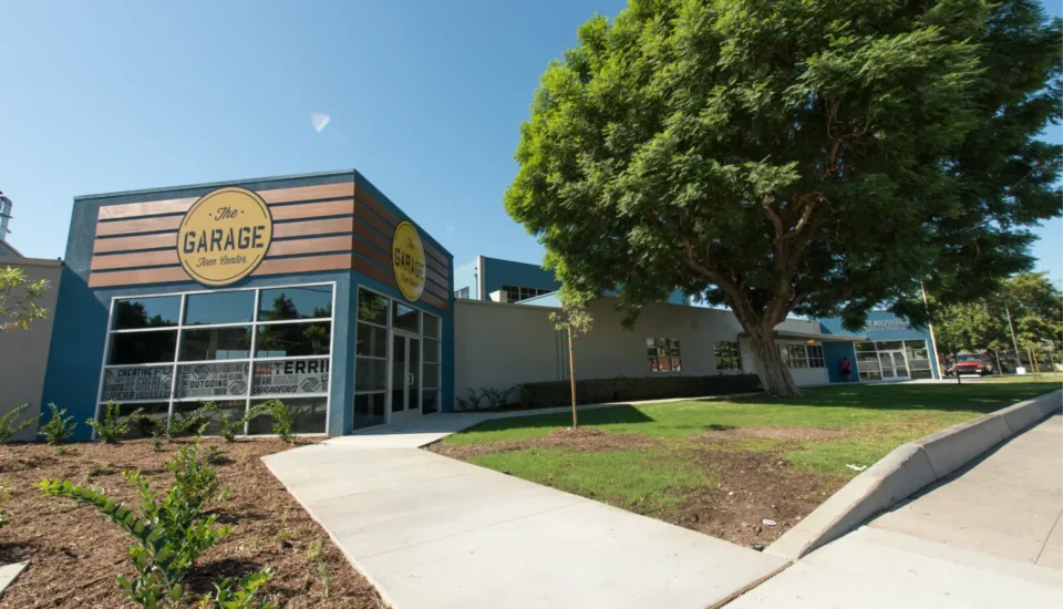 Exterior of Boys & Girls Club teen center designed by architecture company Visioneering Studios, featuring front entry and 'The Garage' signage.