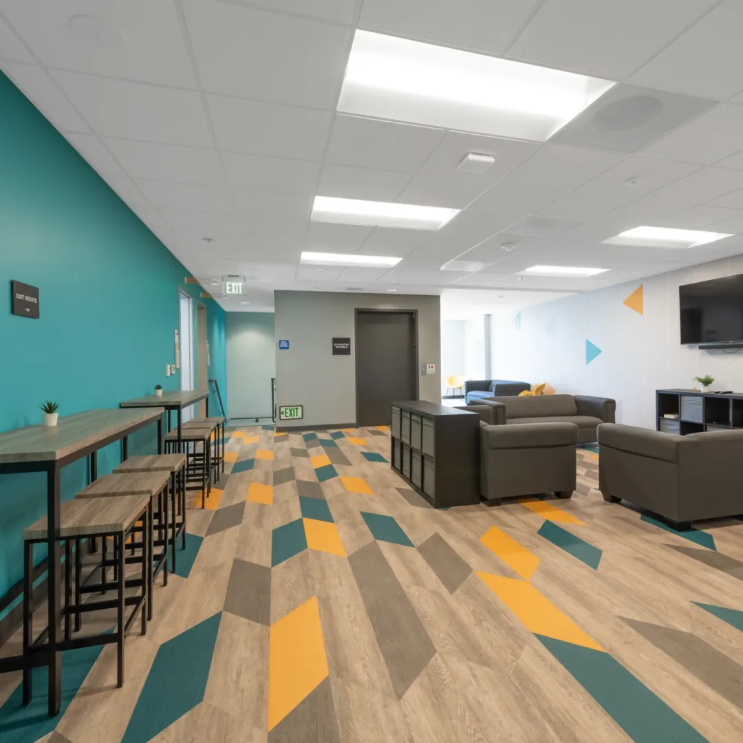 church design build firm visioneering studios. photo highlighting mesa church student interiors which includes new paint, flooring and furniture for student hangout space which includes mesa church brand colors for the kids and student space in the design