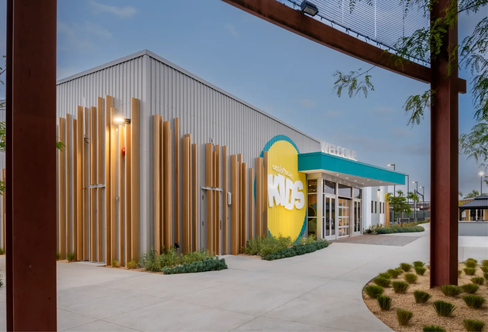 Exterior view of Seabreeze Church by Visioneering Studios from a different angle, showing the building’s modern architecture beneath a steel structure that faces the kids building