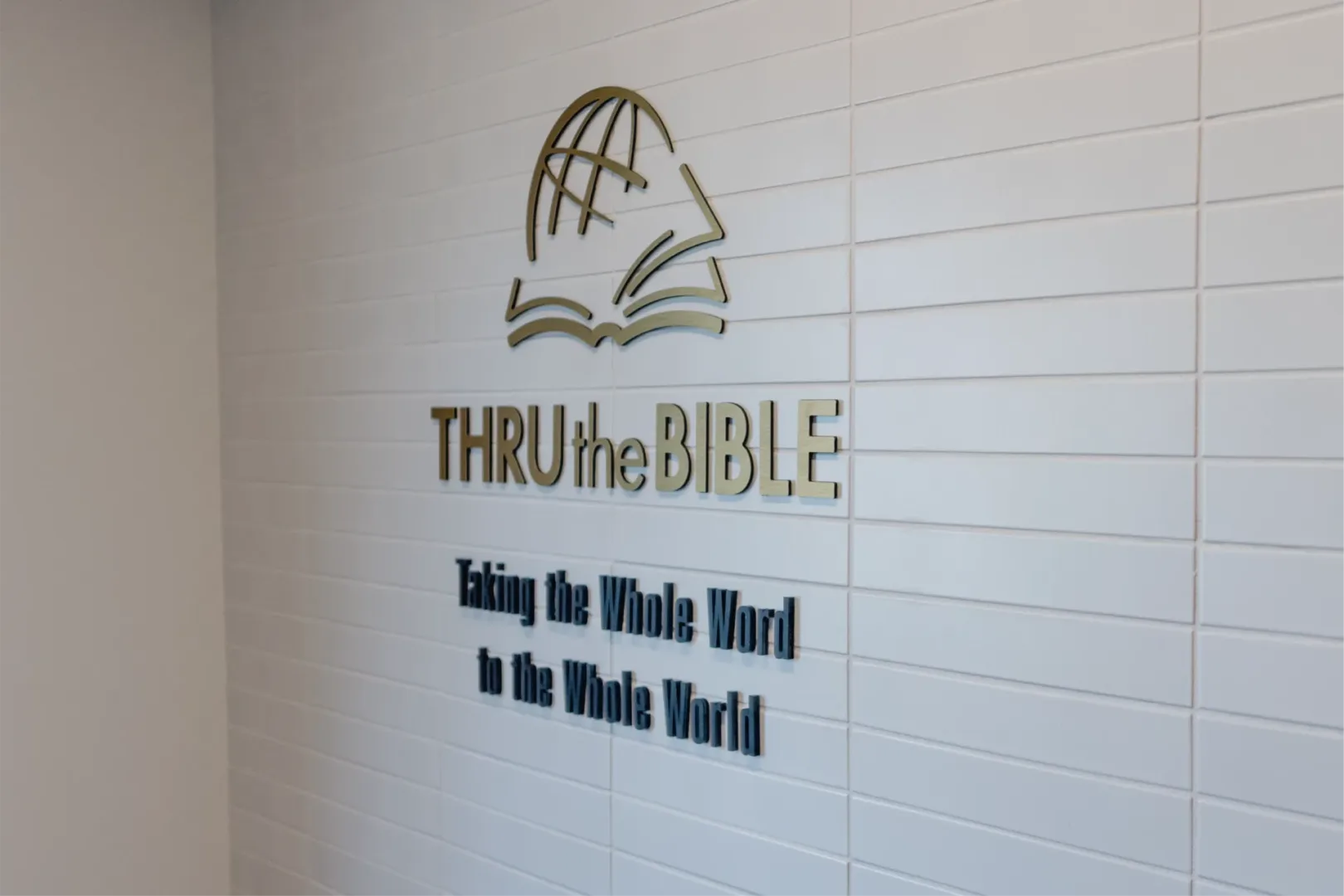 architect firm visioneering studios helped lead Thru the Bible headquarters photo is highlighting entryway wall with logo