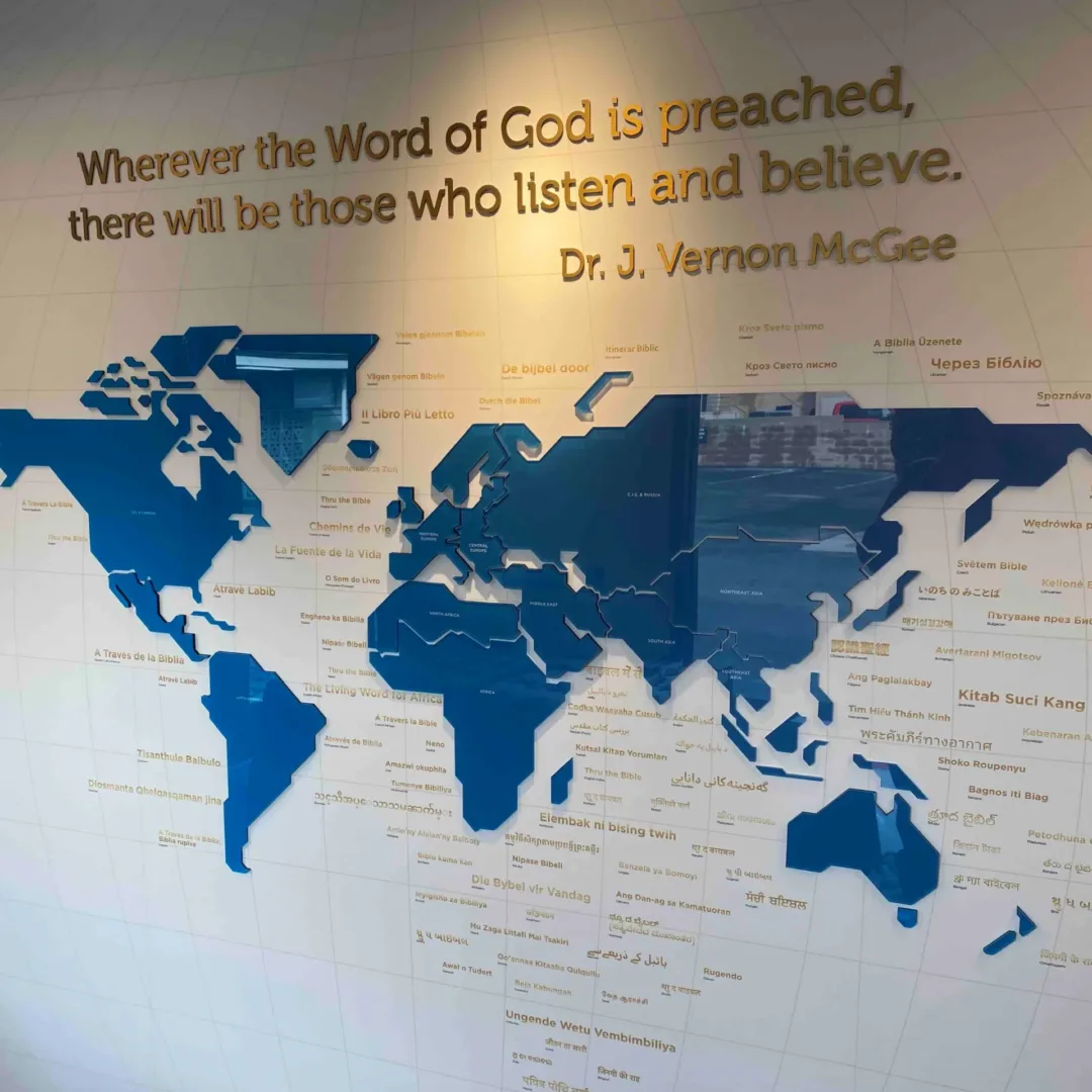 A 3D world map installation at Thru the Bible headquarters with textured continents and a quote from Dr. J. Vernon McGee that reads, “Wherever the Word of God is preached, there will be those who listen and believe.” designed by interior design firm visioneering studios